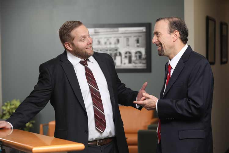 Attorneys Anthony J. Viorst and David Chambers talking in the office
